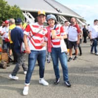 Shinichi and Ikuko Goke pose for a photo before Saturday\'s England-Australia quarterfinal at Oita Stadium. | KAZ NAGATSUKA