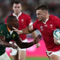 Wales flyhalf  Dan Biggar (right) tries to elude South Africa’s Makazole Mapimpi during their Rugby World Cup semifinal on Sunday in Yokohama.  | AFP-JIJI