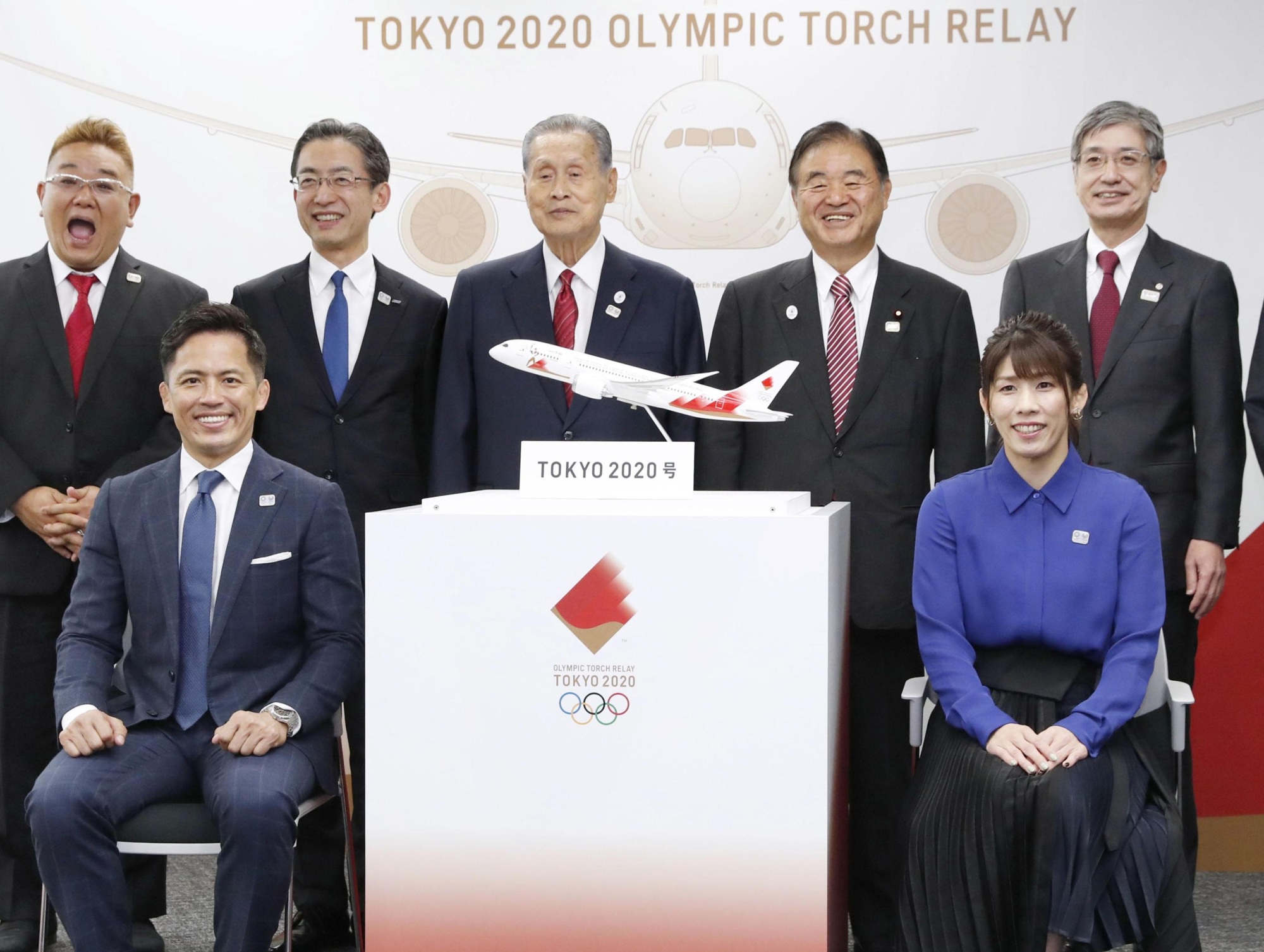 Tadahiro Nomura (first row, left) and Saori Yoshida (right) participate in a photo session along with Tokyo 2020 organizers and others on Friday in Tokyo. An overview of the Tokyo Olympic torch arrival ceremony was announced on the same day. | KYODO