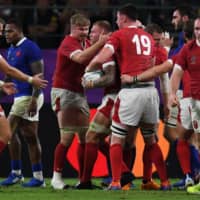 Welsh players react after back row Ross Moriarty (center) scored the crucial try during Sunday\'s Rugby World Cup quarterfinal against France in Oita. | AFP-JIJI
