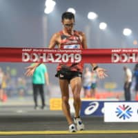 Toshikazu Yamanishi crosses the finish line to win the men\'s 20-km race walk at the IAAF World Athletics Championships in Doha on Saturday. | AFP-JIJI