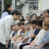 Crown Prince Naruhito and Crown Princess Masako speak with individuals affected by the 2011 Great East Japan Earthquake and tsunami at a temporary housing facility in Shichigahama, Miyagi Prefecture, on Aug. 20, 2013. | KYODO