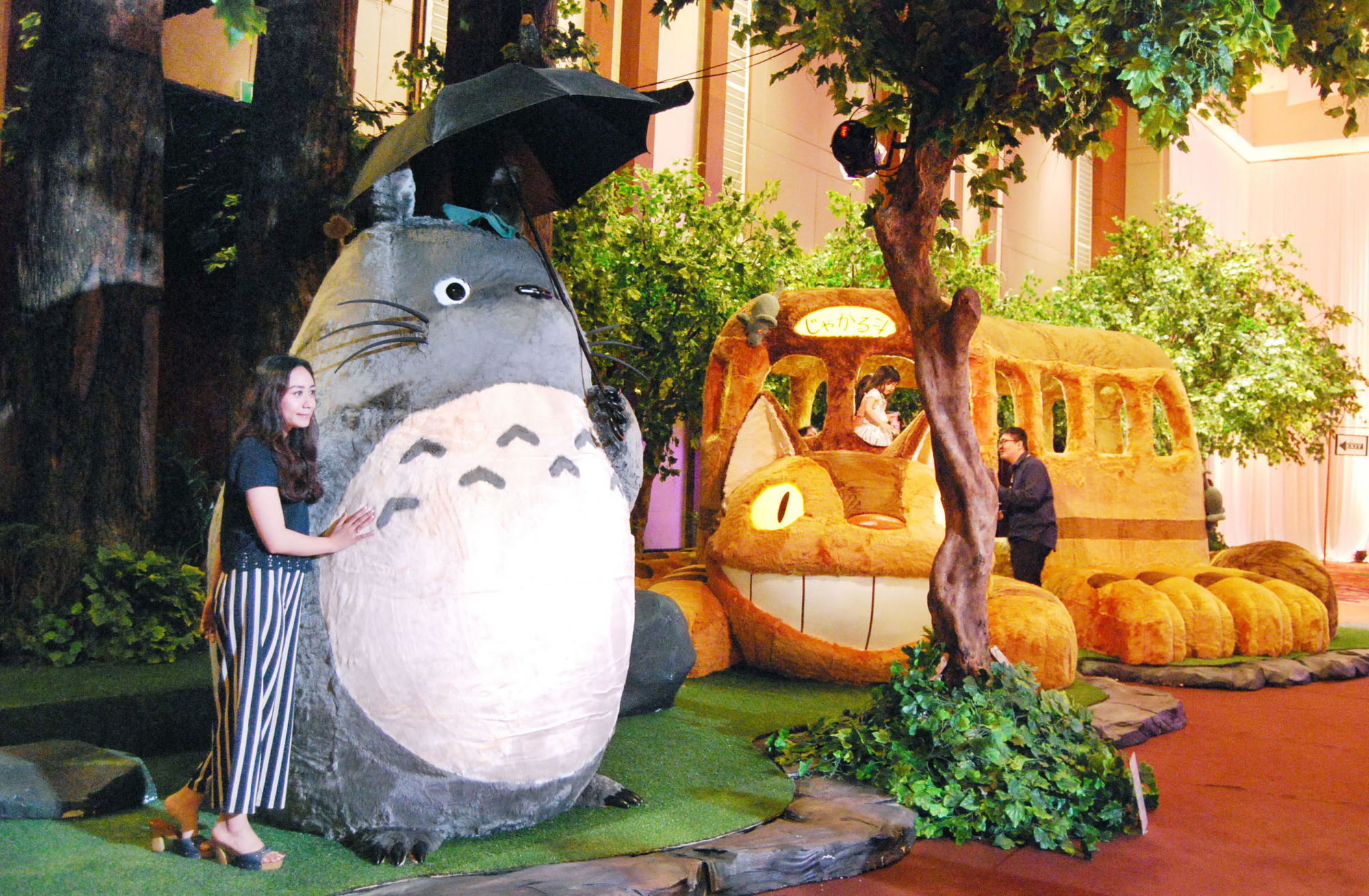 A visitor takes a photo with characters from the popular Japanese anime 'My Neighbor Totoro' in September in Jakarta. Netflix Inc. is now introducing more Japanese anime works to lure fans from outside Japan. | KYODO