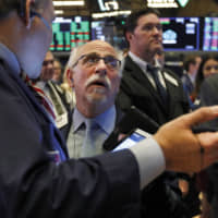 Trader Peter Tuchman (center) works on the floor of the New York Stock Exchange on Thursday. | AP