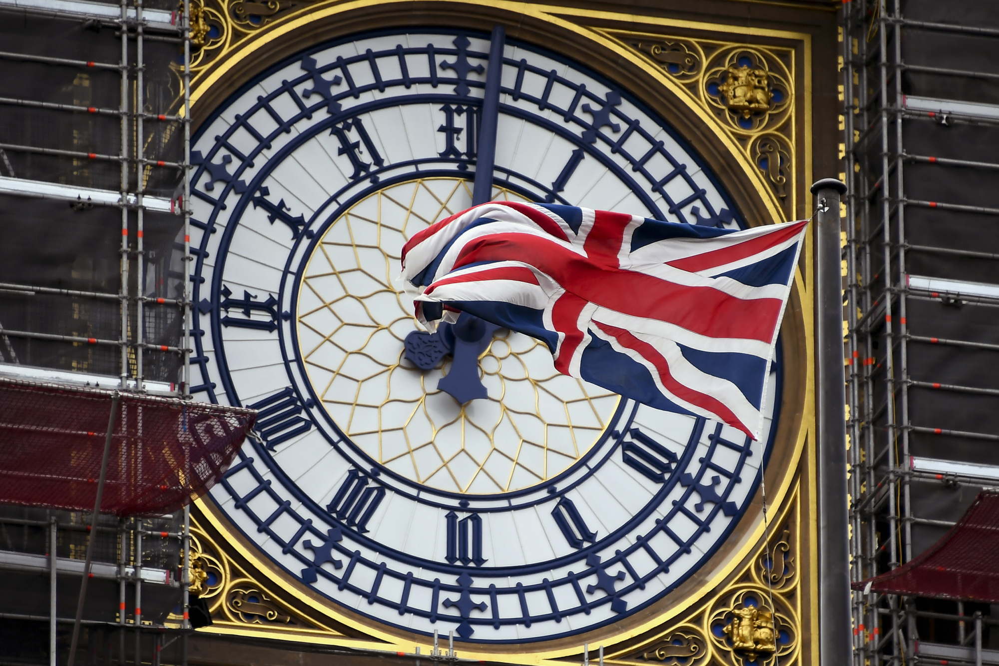 A U.K. flag waves against the backdrop of the clock facade of the Elizabeth Tower, which holds the bell known as Big Ben, in London on Friday. | AP