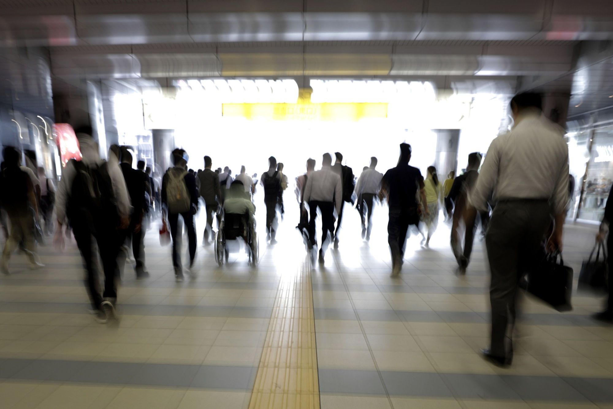 Morning commuters make their way to work in Tokyo on July 9. JR East is planning to introduce 'walk-through' ticket gates that communicate with a specialized apps on passengers' smartphones. | BLOOMBERG