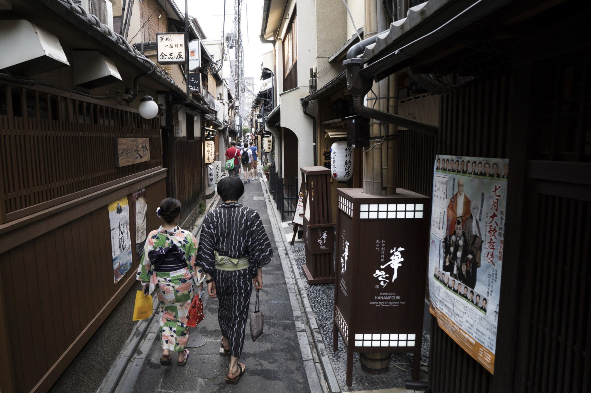 A couple wearing rental kimono walk through the Pontocho dining area of Kyoto. The tourist destination is considering the sale of debt to finance environmental, social and governance projects, according to its mayor. | BLOOMBERG