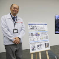 Engineer Makoto Yamada talks to reporters about using robotics for sealing as part of Nissan\'s new production methods at its intelligent factory during a news conference at the company\'s headquarters in Yokohama on Thursday. | AP