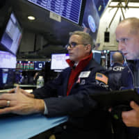 FILE &#8212; In this Nov. 20, 2019, file photo specialist Anthony Rinaldi (left) and trader Michael Urkonis work on the floor of the New York Stock Exchange. | AP