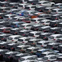 Vehicles for export await shipment at a port in Kawasaki in September. | BLOOMBERG