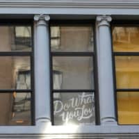 A sign is seen in a window at the WeWork corporate headquarters in Manhattan, New York, Thursday. | REUTERS