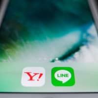 The icons for the Yahoo Japan and Line apps are displayed on a smartphone. | BLOOMBERG