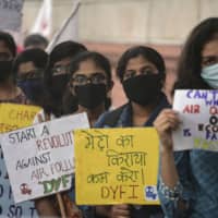 Demonstrators wearing face masks due to heavy smog conditions take part in a protest demanding government measures to curb air pollution in New Delhi on Sunday. India\'s capital was enveloped in heavy, toxic smog &#8212; the worst levels in recent years &#8212; with flights diverted or delayed as politicians blamed each other for failing to tackle the crisis. | AFP-JIJI