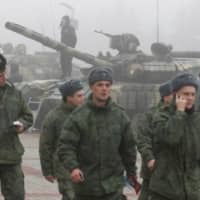 Servicemen attend an army equipment and weaponry exhibition marking the fifth anniversary of the creation of the separatist Donetsk People\'s Republic\'s armed forces on a foggy autumn day in Donetsk, Ukraine, Tuesday. | REUTERS