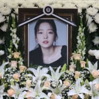 The portrait of late K-pop star Goo Hara is seen surrounded by flowers at a memorial altar at a hospital in Seoul on Monday. | AFP-JIJI