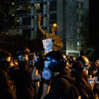 Protesters gather in front of the \'Goddess of Democracy\' statue on campus after clashes with police at the Chinese University of Hong Kong (CUHK), in Hong Kong early Wednesday. Hong Kong pro-democracy protesters clashed with riot police in the city\'s upmarket business district and on university campuses Tuesday, extending one of the most violent stretches of unrest seen in more than five months of political chaos. | AFP-JIJI