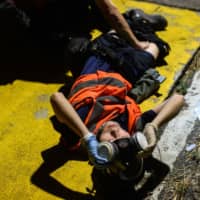 A medic is injured during clashes with police at the Chinese University of Hong Kong (CUHK) in Hong Kong on Tuesday. | AFP-JIJI
