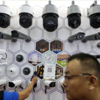 Visitors to the China Public Security Expo look at Huawei surveillance cameras in Shenzhen on Oct. 29. | AP