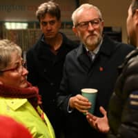 Britain\'s opposition Labour Party leader Jeremy Corbyn, accompanied by Labour MP for Doncaster North, Ed Miliband, talks to flood-affected residents during a visit to the Bentley suburb of Doncaster, Britain, Tuesday. | OLI SCARFF / POOL / VIA REUTERS