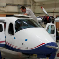 Technicians work on the X-57 Maxwell all-electric plane in a hangar at NASA\'s Armstrong Flight Research Center at Edwards Air Force Base, California, on Friday. | REUTERS