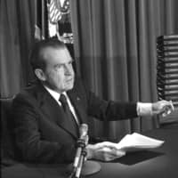 Then-President Richard M. Nixon points to the transcripts of the White House tapes in Washington, after he announced on television that he would turn over the transcripts to House impeachment investigators, in April 1974. The public impeachment inquiry hearings this week usher in a rare and momentous occasion in American history as Congress debates whether to remove a sitting president from office. | AP