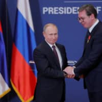 Russian President Vladimir Putin (left) decorates Serbian President Alexandar Vucic with an order of Alexander Nevsky after their meeting in Belgrade in January. | MAXIM SHIPENKOV / POOL / VIA REUTERS