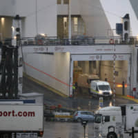 A garda police van is seen at Rosslare Europort aboard a Stena Line ferry after 16 people were discovered inside a sealed trailer on the ship sailing from France, in Co Wexford, southern Ireland, Thursday. | NIALL CARSON / PA / VIA AP