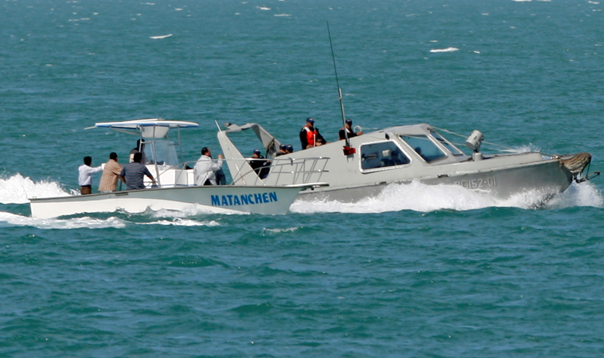 A Mexican patrol boat (right) checks the boat of a fisherman as they stand guard over California Gulf porpoises, also known as vaquitas, in San Felipe in Mexico's state of Baja California in 2008. The vaquita, a tiny stubby-nosed porpoise found only in Mexico's Sea of Cortez, is on the brink of extinction as more die each year in fishing nets than are being born, biologists say. | REUTERS