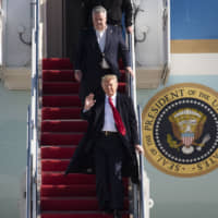 President Donald Trump waves as he exits Air Force One with Rep. Peter King on Sunday at Andrews Air Force Base, Maryland. after a trip to New York City to attend a mixed martial arts fight at Madison Square Garden. | AP