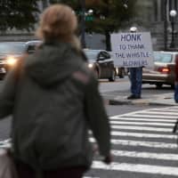 Julian, who only gave his first name in fear of his personal safety, stands on a corner with a sign supporting whistleblowers near the White House in Washington Wednesday. | REUTERS