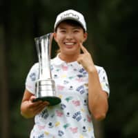 Hinako Shibuno holds the trophy as she poses for photos following her victory at the Women\'s British Open in August in Milton Keynes, England. |  ACTION IMAGES VIA REUTERS