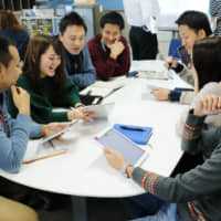 Work-style reforms at Aisen Seiki Co. include a casual dress code and using tablets to cut down on printed documents. | AISIN SEIKI CO. / VIA CHUNICHI SHIMBUN