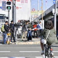 Reporters gather Saturday near the site where Ryotaro Oue, who has been indicted for using illegal stimulants and possessing marijuana, escaped in Higashiosaka, Osaka Prefecture. He was re-apprehended on Monday. | KYODO