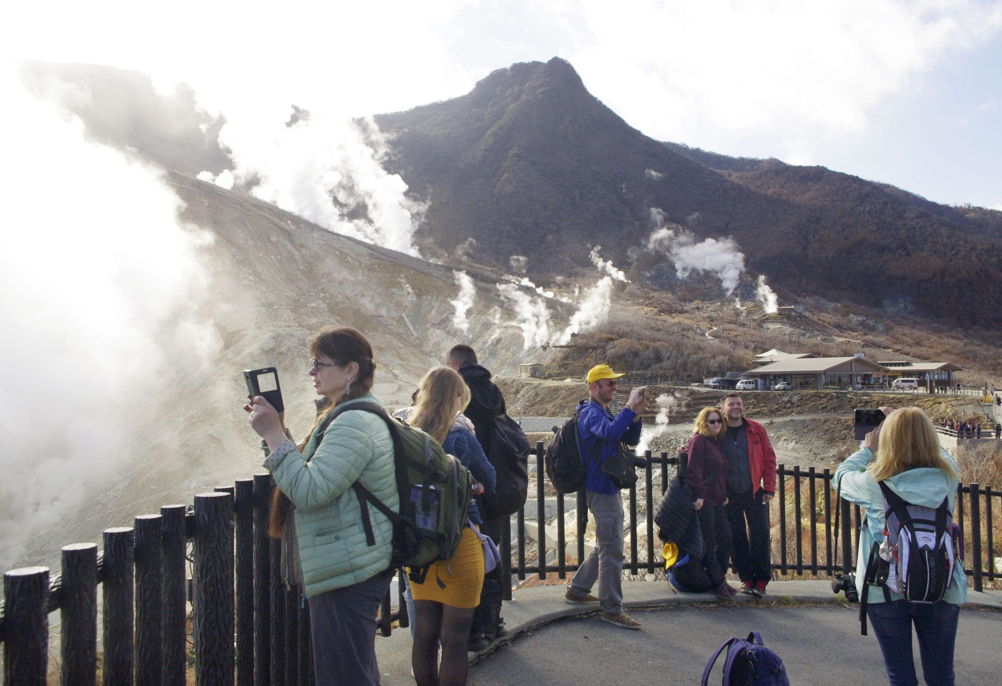Tourists take pictures at the Owakudani area in Hakone, Kanagawa Prefecture, on Friday after it was reopened to the public following the lowering of the volcanic alert level for Mount Hakone. | KYODO
