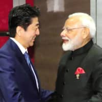 Prime Minister Shinzo Abe and Indian leader Narendra Modi meet Monday on the outskirts of Bangkok. | POOL / VIA KYODO
