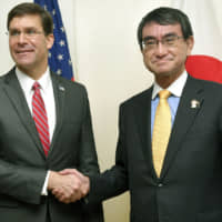 U.S. Defense Secretary Mark Esper and Defense Minister Taro Kono shake hands after meeting Monday in Bangkok on the sidelines of an expanded defense meeting of the Association of Southeast Asian Nations. | KYODO