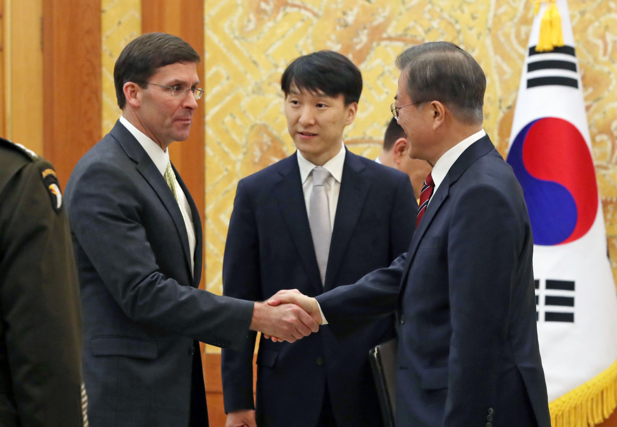South Korean President Moon Jae-in (right) greets U.S. Defense Secretary Mark Esper before their meeting at the presidential Blue House in Seoul on Friday. | AP