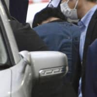 Ryosuke Saito is escorted to a police station Monday in the city of Niigata. He is suspected of fatally stabbing 20-year-old Yuzuki Ishizawa on Friday evening. | KYODO