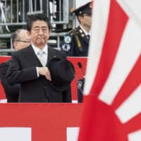 Prime Minister Shinzo Abe reviews Self-Defense Forces troops at the Ground Self-Defense Force\'s Camp Asaka in October last year. | BLOOMBERG