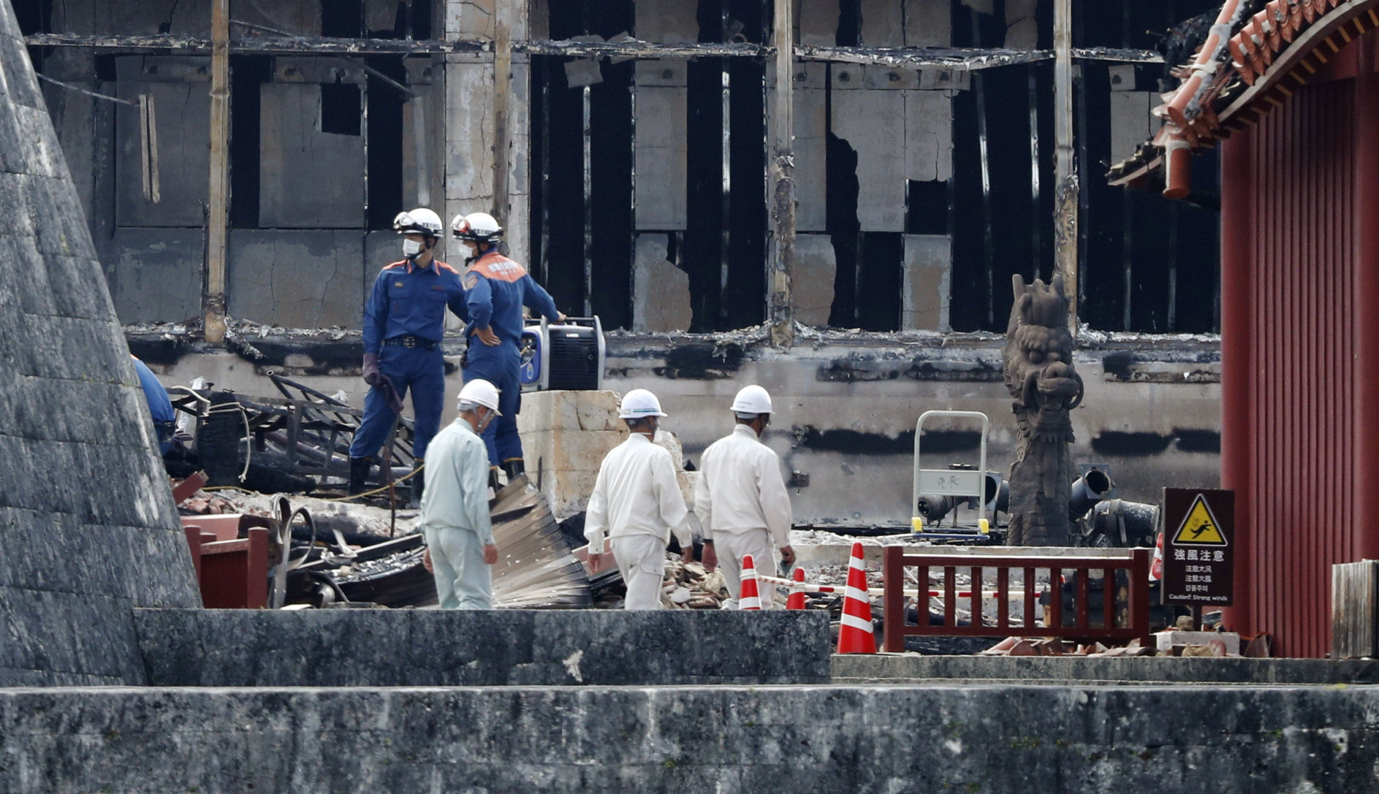 Firefighters conduct an investigation in the remains of Shuri Castle's Seiden main hall in Naha, Okinawa Prefecture, on Tuesday. Buildings located together with the UNESCO World Heritage site were destroyed by a major fire last week. | KYODO