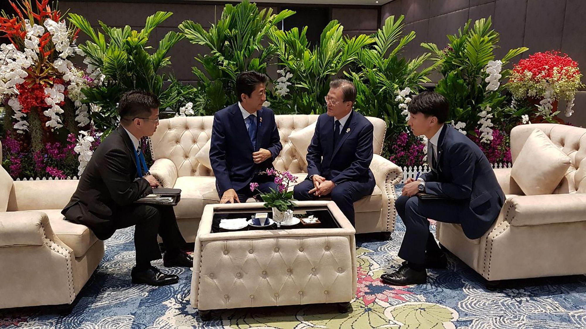 South Korean President Moon Jae-in and Prime Minister Shinzo Abe meet on the sidelines of the ASEAN summit in Bangkok on Monday in this photo released by the South Korean presidential office. | AFP-JIJI
