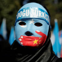 Speaking out: An ethnic Uighur demonstrator wears a mask as she attends a protest against China in front of the Chinese Consulate in Istanbul. | REUTERS