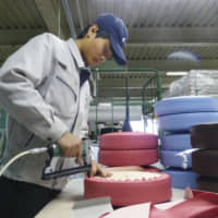 Getting the job done: A Vietnamese trainee works at a factory in Okazaki, Aichi Prefecture. | ?¯