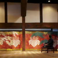 Two of a kind: A pair of six-panel folding screens, featuring cherry and pine boughs against a samurai-era battle-camp curtain sporting family crests in the classic goshichi no kiri (five-seven-five paulownia) style, stretches the length of the main hall of the Takishita residence. The room\'s central pillar conceals the gap between the two screens. Although byōbu  were often created in pairs, few perfect sets like this one remain intact today. Yoshihiro Takishita admires the Meiji Era (1868-1912) screens from a low chair once used for meditation by Chinese monks. | REUTERS