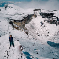 The author stands at the summit on Sunday, the day before an unidentified livestreamer was captured on video falling from the top of Mount Fuji. | MATTHEW KAZUO FIRPO