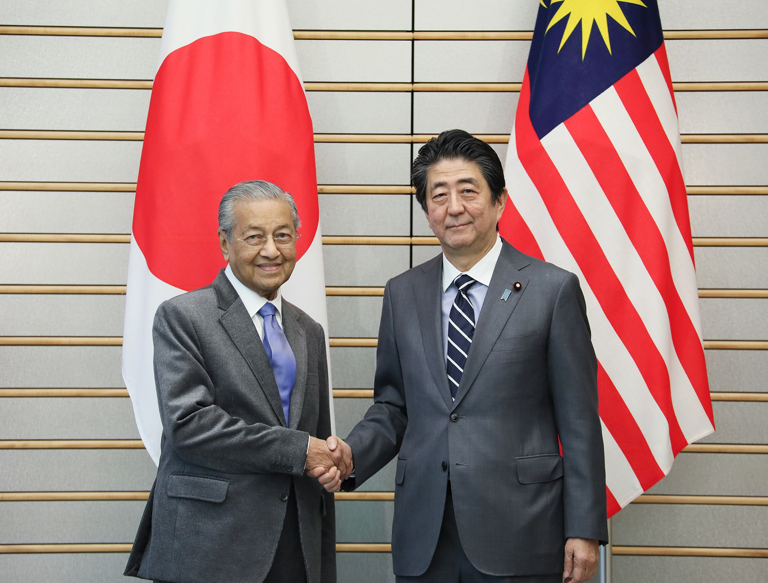 Malaysian Prime Minister Tun Dr. Mahathir Mohamad and Japanese Prime Minister Shinzo Abe shake hands during their meeting in Tokyo on May 31. Mahathir has adopted the Look East Policy modeled after Japan's economic growth since his first term as prime minister between 1981 and 2003. | CABINET PUBLIC RELATIONS OFFICE