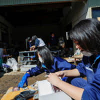 Student volunteers in Date, Fukushima Prefecture, clear debris Oct. 16 from an elderly person\'s home in the aftermath of Typhoon Hagibis. | REUTERS