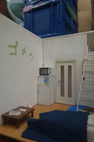A model of an apartment room with 'gomen' ('sorry') written on the wall. | ALEX MARTIN