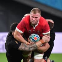 Wales\' Ross Moriarty (C) is tackled by New Zealand players on Friday night. | AFP-JIJI