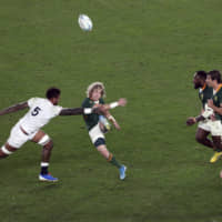 South Africa\'s Faf de Klerk kicks the ball as England\'s Courtney Lawes (left) defends on Saturday. | AP